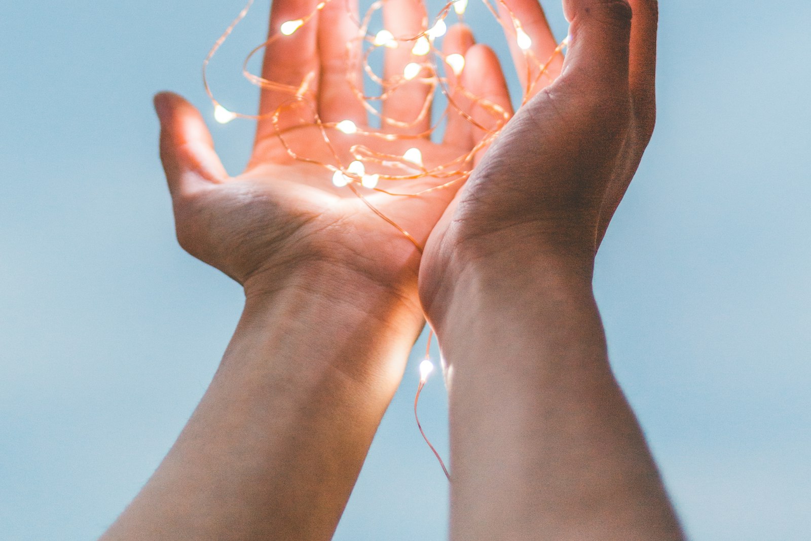 Open hands cupping a soft glow of light