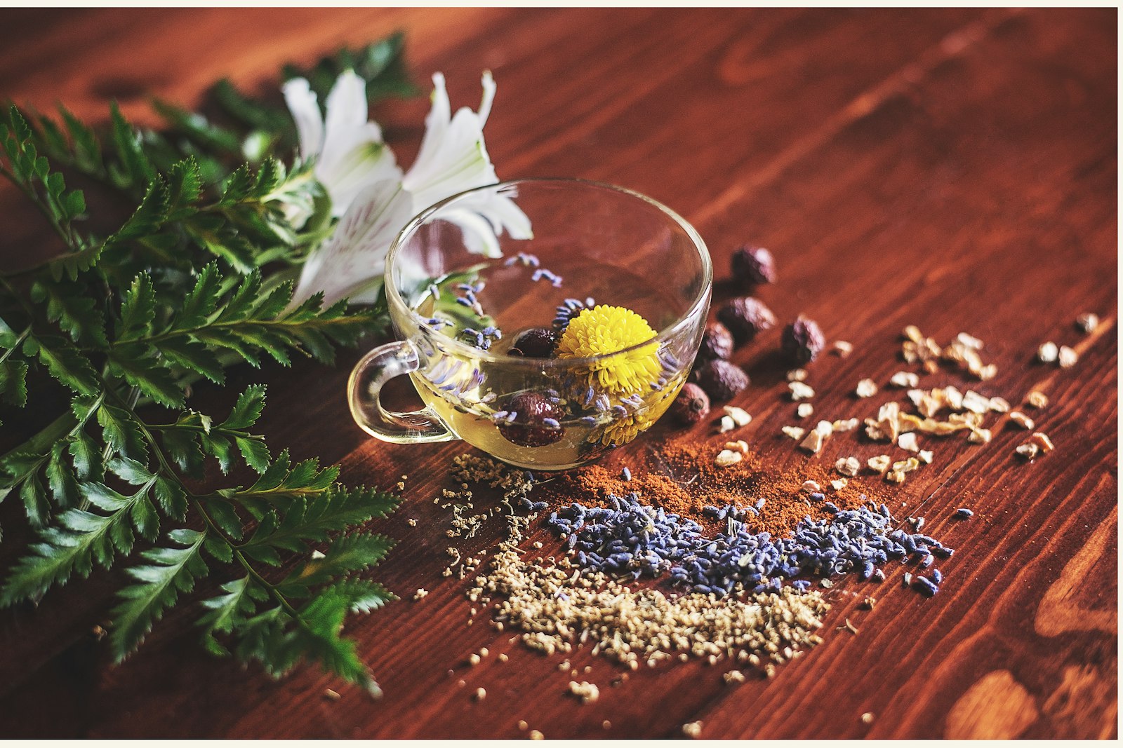 Herbs and infused oil laid out on a wooden table