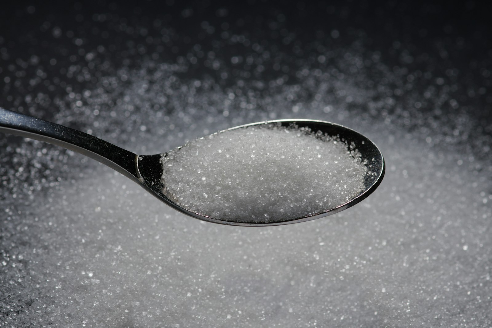 A spoonful of sugar levelled against a grey surface