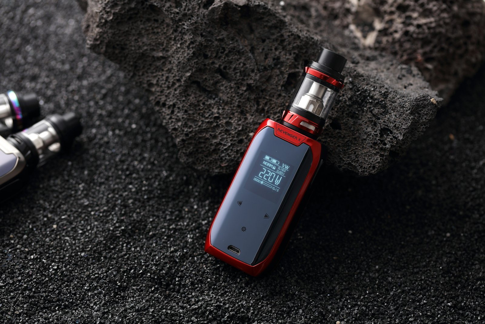 An e-cigarette device resting on dark stone