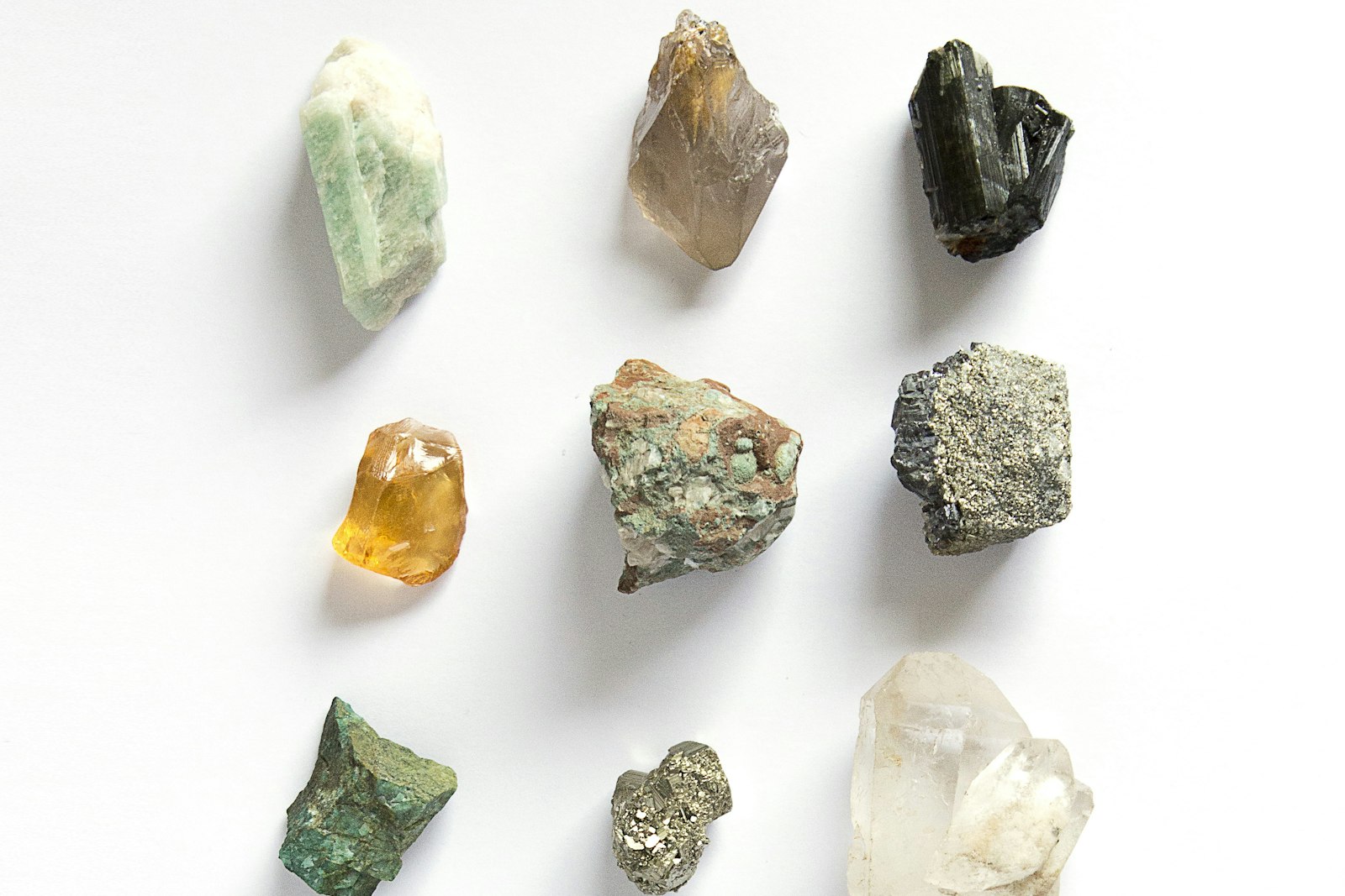 Raw crystals arranged in a grid on a pale surface