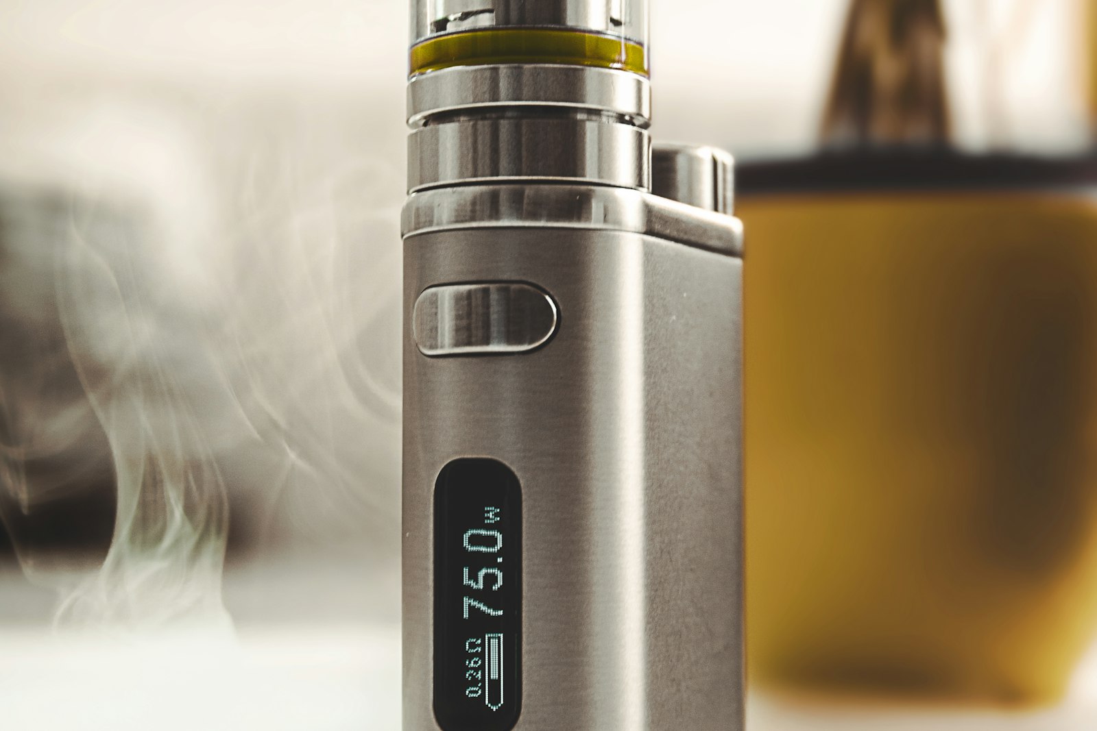 A vape device and its liquid set down on a table