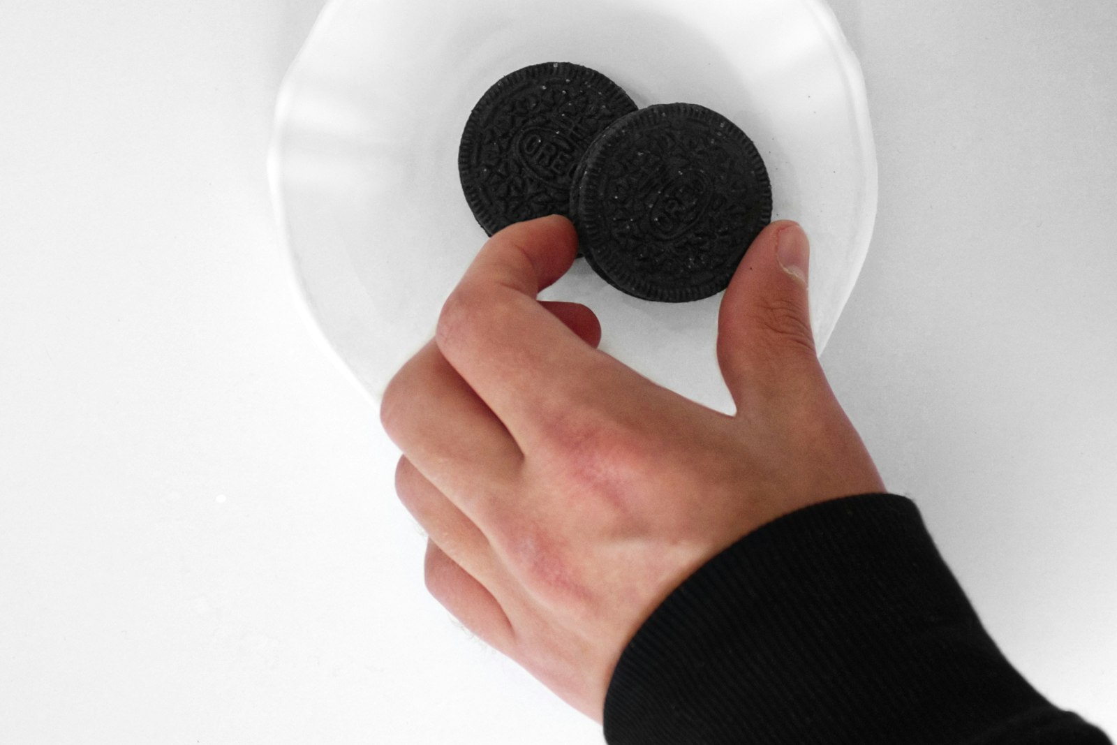 A hand reaching for biscuits on a plate mid-afternoon