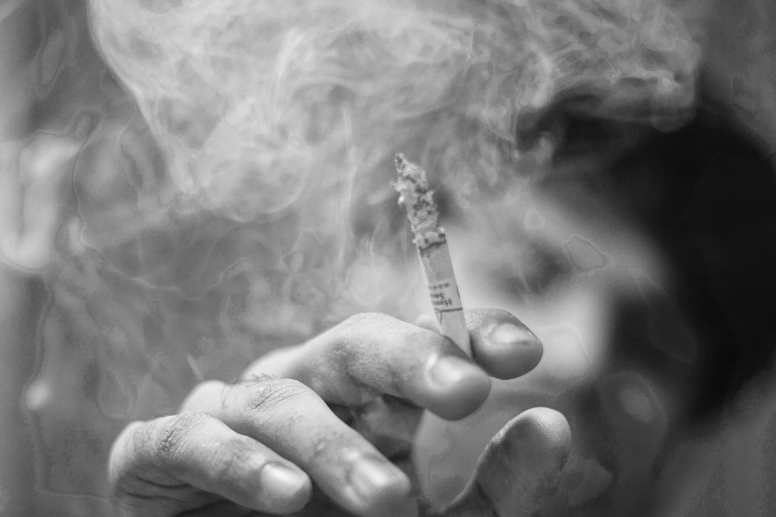 A cigarette held in a hand, drawn in black and white
