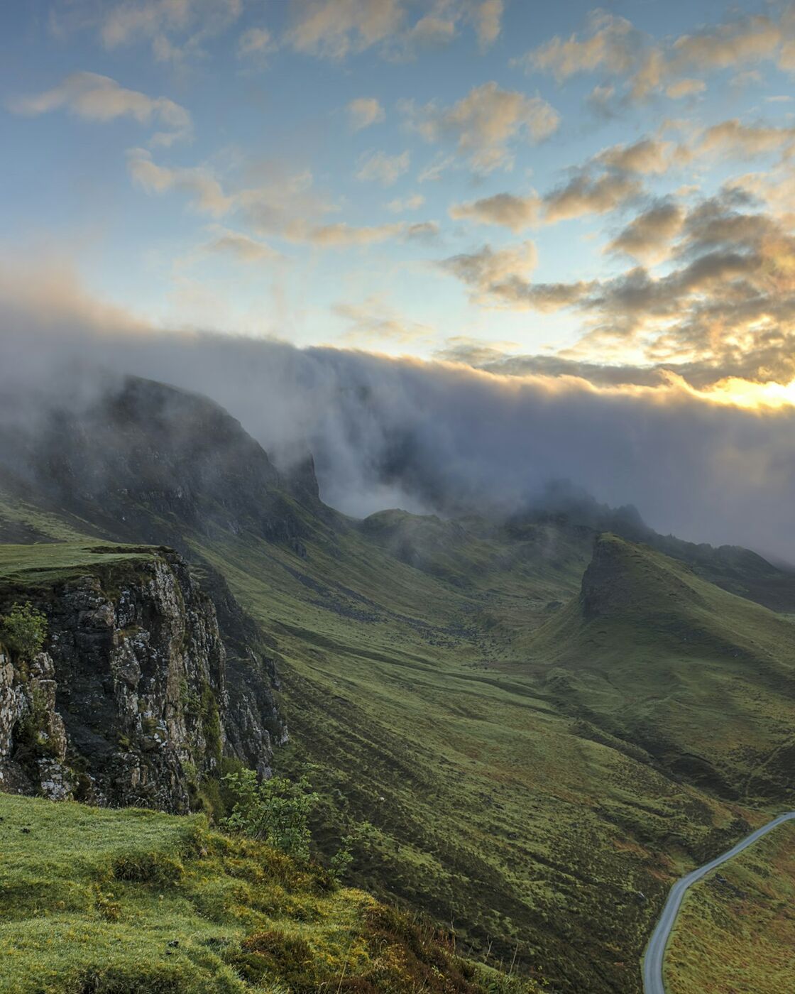 Mist settling over green highland hills at first light